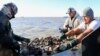 Pemanen tiram Ignacio Jorge, Juan Jorge, dan Joel Gutierrez memisahkan bebatuan dan cangkang kerang untuk mencari tiram di Galveston Bay, Texas, AS, 2 November 2023. (REUTERS/Evan Garcia)