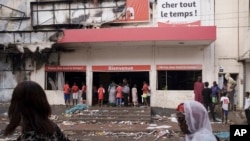 People stand at the entrance of a destroyed supermarket in Dakar, Senegal, June 3, 2023.