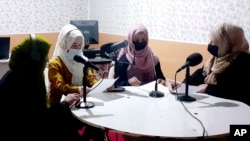 Najia Sorosh head of Sadai Banowan a women-run radio station, right, sits with staff in the station's broadcasting studio in Badakhshan province, Afghanistan, March 7, 2023. The station has resumed broadcasting after officials shut it for a week for playing music during Ramadan.