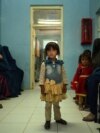 FILE - A child stands in a waiting room at a clinic run by the Swedish Committee for Afghanistan, in Wardak province, Afghanistan, Oct. 6, 2021. The SCA was forced to halt its activities last year, including services for new mothers and support programs for the disabled. 