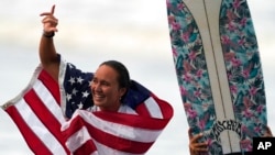 FILE - Carissa Moore, of the United States, celebrates winning the gold medal in the women's surfing competition at the 2020 Summer Olympics at Tsurigasaki beach in Ichinomiya, Japan, July 27, 2021.