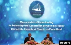 Somaliland President Muse Bihi Abdi, right, and Ethiopia’s Prime Minister Abiy Ahmed attend the signing of the Memorandum of Understanding agreement that allows Ethiopia to use a Somaliland port, in Addis Ababa, Ethiopia, Jan. 1, 2024.