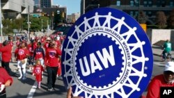 FILE - United Auto Workers members walk in the Labor Day parade in Detroit, Sept. 2, 2019. 