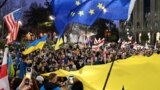 格鲁吉亚民众在首都第比利斯街头举着乌克兰、欧盟和美国的旗帜游行纪念俄乌战争爆发两周年。（法新社2024年2月24日）