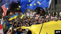 格鲁吉亞民眾在首都第比利斯街頭舉著烏克蘭、歐盟和美國的旗幟遊行紀念俄烏戰爭爆發兩週年。（法新社2024年2月24日）