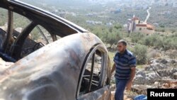 2023年12月3日，一名巴勒斯坦男子在以色列佔領的約旦河西岸薩爾菲特附近檢查一輛在以色列定居者突襲中被燒毀的汽車。 （路透社照片）