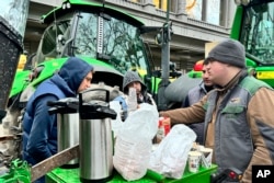 Farmers share a breakfast in the center of Brussels, Belgium, Jan. 31, 2024, ahead of a blockade Thursday.