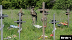 یک سرباز روس در گورستانی در مناطق اشغال شده اوکراین