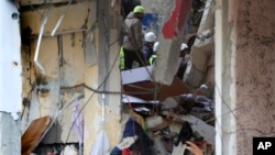 Civil defense and rescue workers on Feb. 15, 2024, remove rubble from a building hit by an Israeli airstrike, in Nabatiyeh town, south Lebanon.