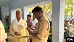 印度安全人员在允许选民进入投票站投票之前检查选民的文件 (美国之音/贾尚杰)