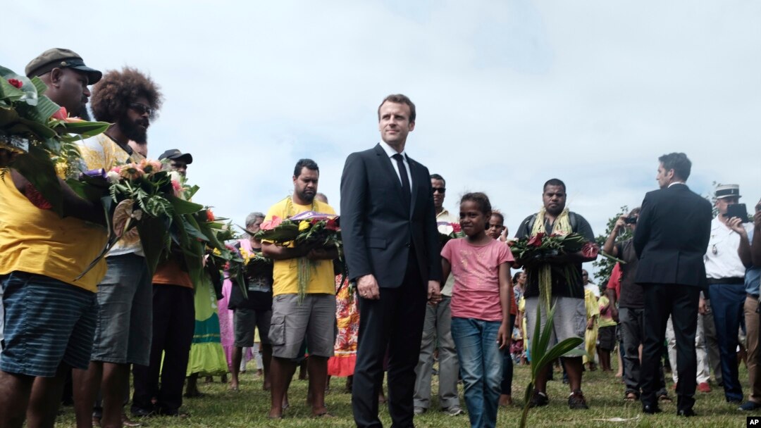 FILE - French President Emmanuel Macron pays tribute to the Kanak tribe of Hwadrilla, where the 19 Kanak militants are buried, on Ouvea Island, off New Caledonia, May 5, 2018. 