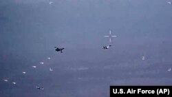 Na fotografiji napravljenoj od video zapisa, koji je objavila Konanda vazduhoplovstva SAD, vidie se ruski borbeni avioni SU-34 i SU-35 kako izbacuju toplotne mamce na put bespilotne letjelice MQ Riper, 6. juna 2023, iznad Sirije.