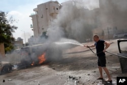 Cars are on fire after they were hit by rockets from the Gaza Strip in Ashkelon, Israel, on Oct. 7, 2023. (AP Photo/Ohad Zwigenberg, File)