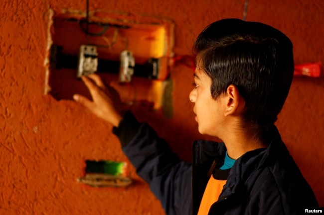 Displaced Palestinian teenager Hussam Al-Attar, nicknamed by people 'Newton', shows an electrical panel at a tent camp in Rafah, in the southern Gaza Strip, February 6, 2024. (REUTERS/Ibraheem Abu Mustafa)