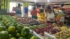 ARCHIVO - Una cliente observa uvas y fresas en un negocio de comida en Maracaibo, en el occidente de Venezuela, en julio de 2023.