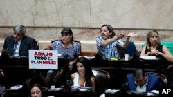 Sebuah poster yang bertuliskan "Hapus semua rencana Milei" dalam Bahasa Spanyol dipasang oleh anggota parlemen dari kubu oposisi dalam pembahasan RUU Omnibus di gedung Kongres di Buenos Aires, Argentina, pada 31 Januari 2024. (Foto: AP/Natacha Pisarenko) 