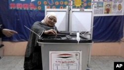 A woman casts her vote for the presidential elections at a polling station in Cairo, Dec. 10, 2023.
