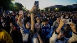 FILE - People take smartphone photos of the crowd on a street near Tiananmen Square as visitors gather to watch a flag-raising ceremony on the National Day in Beijing, Sunday, Oct. 1, 2023. (AP Photo/Andy Wong, File)