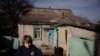 Mykyta, un niño de 13 años con problemas de aprendizaje, aguarda en la entrada de su casa. Vive en el pueblo de Tetyanivka, a menos de 30 kilómetros de la guerra que azota la región ucraniana de Donetsk.