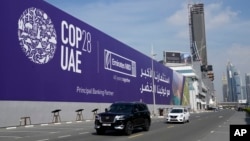 Vehículos transitan junto a una valla publicitaria de la COP28 en la autopista Sheikh Zayed en Dubái, Emiratos Árabes Unidos, el 27 de noviembre de 2023.
