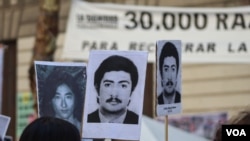 Manifestantes sostienen carteles con la foto de sus familiares desaparecidos durante la marcha por el Día de la Memoria por la Verdad y la Justicia en la Ciudad de Buenos Aires. [Foto: Lisandro Concatti]