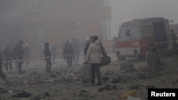 Local residents stand near their residential building, destroyed during a Russian missile and drone strike, amid Russia's attack on Ukraine, in Odesa, Ukraine.