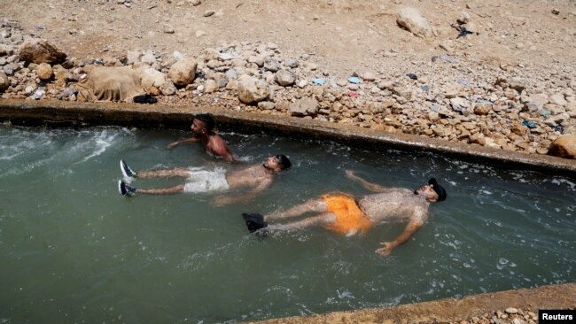 Palestinians cool off during a heat wave, in al-Oja springs near Jericho in the Israeli-occupied West Bank, July 18, 2023.