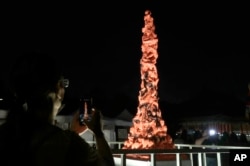 People take photos to the imitation of Pillar of Shame during a candlelight vigil at Democracy Square in Taipei, Taiwan, June 4, 2023.