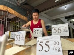 Ronnel Gardon tends rice supplies at a shop in Manila, Sept. 21, 2023.