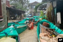 Residents bring their boats to prevent them from being swept away by a swollen river due to Typhoon Doksuri in Laoag city, Ilocos Norte province, northern Philippines, July 26, 2023.