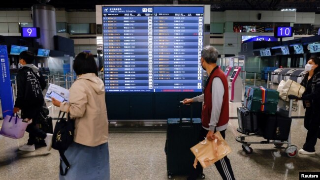 People look at flight information at Taiwan Taoyuan International Airport in Taoyuan, Taiwan, April 12, 2023.