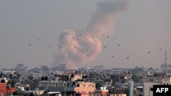 A picture taken from Rafah in the southern Gaza Strip shows smoke rising over buildings in Khan Yunis following Israeli bombardment on Feb. 5, 2024. 