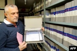 An employee shows a tape in the archives department of Tele Liban in Beirut, Lebanon Dec. 29, 2023.