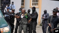 Nigeria Department of State Services has a misunderstanding with the Nigeria correctional service officer, center, during a court hearing with Godwin Emefiele, suspended Central Bank governor, at the Federal High Court in Lagos, Nigeria, July. 25, 2023.