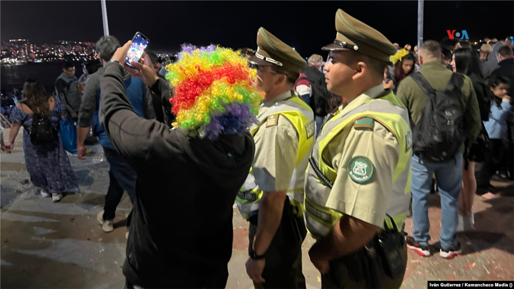 Juliano Olmos, con una colorida peluca, se fotografía con carabineros en la celebración de año nuevo en Viña del Mar, Chile.