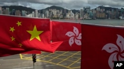FILE - Chinese and Hong Kong flags mark the 25th anniversary of Hong Kong handover to China, in Hong Kong on June 17, 2022.