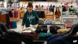 An employee straightens displays at a Kohl's store in Clifton, N.J., Jan. 26, 2024. 