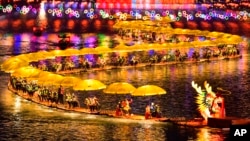 In this photo released by Xinhua News Agency, tourists enjoy a bamboo floating ride on a lake during the Chinese Lunar New Year in Xuan'en County in central China's Hubei Province on Feb. 11, 2024. 