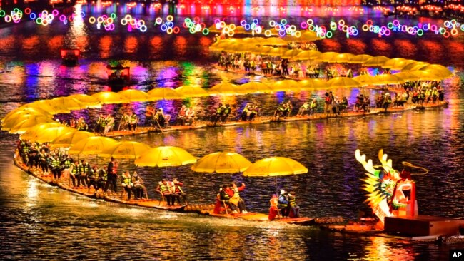 In this photo released by Xinhua News Agency, tourists enjoy a bamboo floating ride on a lake during the Chinese Lunar New Year in Xuan'en County in central China's Hubei Province on Feb. 11, 2024.