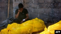 A man mourns by relatives' bodies — found under rubble or on the street — before their burial in Gaza City's al-Sinaa neighborhood, July 12, 2024, following the withdrawal of Israeli troops from the area.