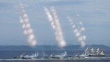 Russian warships fire a salute during the annual Navy Day parade in the far eastern port city of Vladivostok, July 30, 2023. 
