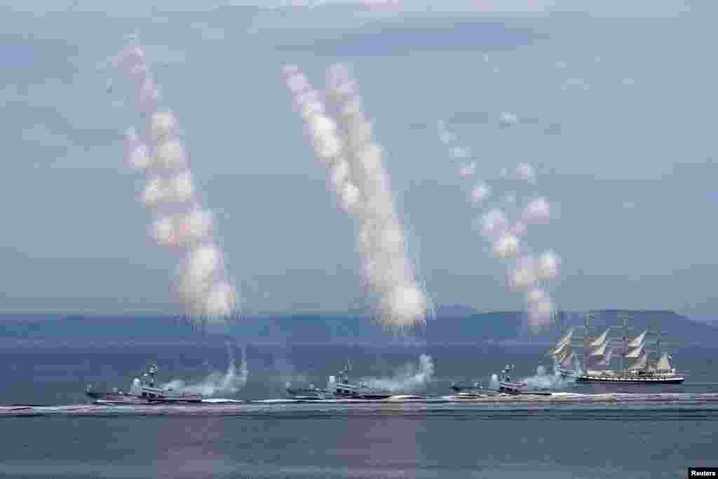 Russian warships fire a salute during the annual Navy Day parade in the far eastern port city of Vladivostok.