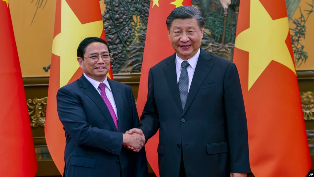 Thủ tướng Việt Nam Phạm Minh Chính (trái) bắt tay Chủ tịch Trung Quốc Tập Cận Bình trước cuộc gặp tại Đại lễ đường Nhân dân ở Bắc Kinh, vào ngày 26/6/2023. Ảnh: Tân Hoa Xã/AP