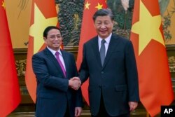 រូបឯកសារ៖ នាយករដ្ឋមន្ត្រីវៀតណាមលោក Pham Minh Chinh និងប្រធានាធិបតីចិនលោក Xi Jinping ចាប់ដៃគ្នា មុនជំនួបពិភាក្សាគ្នានៅទីក្រុងប៉េកាំង ប្រទេសចិន កាលពីថ្ងៃទី២៧ ខែមិថុនា ឆ្នាំ២០២៣។
