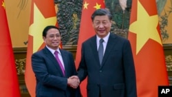 FILE - Vietnam Prime Minister Pham Minh Chinh , left, shakes hands with Chinese President Xi Jinping before their meeting in Beijing, June 27, 2023. Xi will pay a state visit to Vietnam next week.