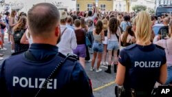 FILE - Police officers stand near a gathering of Taylor Swift fans in Vienna, Austria, Aug.9, 2024. Organizers of all three of Swift's planned concerts in a Vienna stadium were called off over an apparent attack plot.