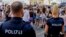 FILE - Police officers stand near a gathering of Taylor Swift fans in Vienna, Austria, Aug.9, 2024. Organizers of all three of Swift's planned concerts in a Vienna stadium were called off over an apparent attack plot.