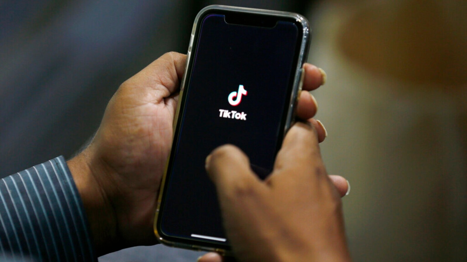 FILE - A man opens social media app TikTok on his cell phone, in Islamabad, Pakistan, July 21, 2020.