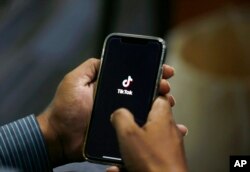 Seorang pria membuka aplikasi media sosial TikTok di ponselnya, 21 Juli 2020. (Foto: AP)