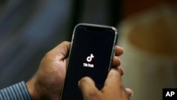 Seorang pria membuka aplikasi TikTok pada telepon genggamnya di Islamabad, Pakistan, pada 21 Juli 2020. (Foto: AP/Anjum Naveed)